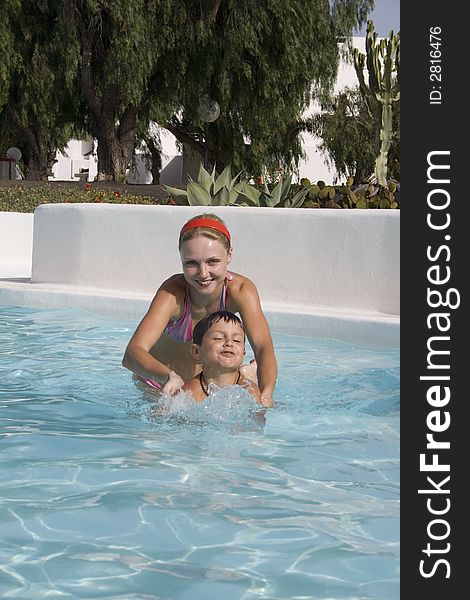 Happy boy and mom in pool