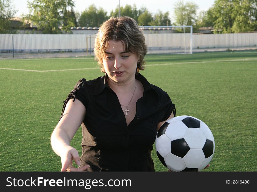 The young woman with a ball in hands gives the instruction on the organization of training on football. The young woman with a ball in hands gives the instruction on the organization of training on football