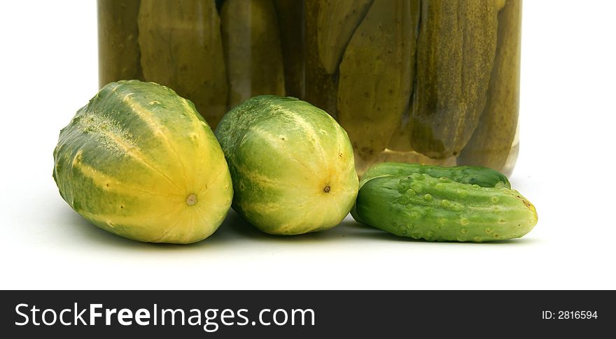 Detail of fresh cucumber with pickles in the background. Detail of fresh cucumber with pickles in the background.