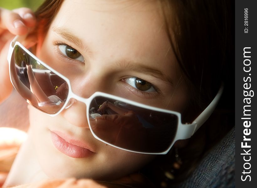 Portrait of an attractive preteen peering over the top of her sunglasses. Portrait of an attractive preteen peering over the top of her sunglasses.