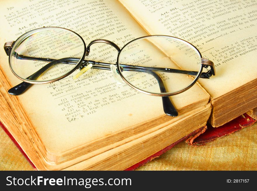 Old glasses over a vintage book of law. Old glasses over a vintage book of law