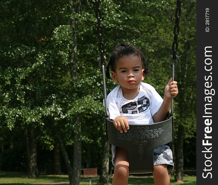 Toddler on the swing at the playground. Toddler on the swing at the playground