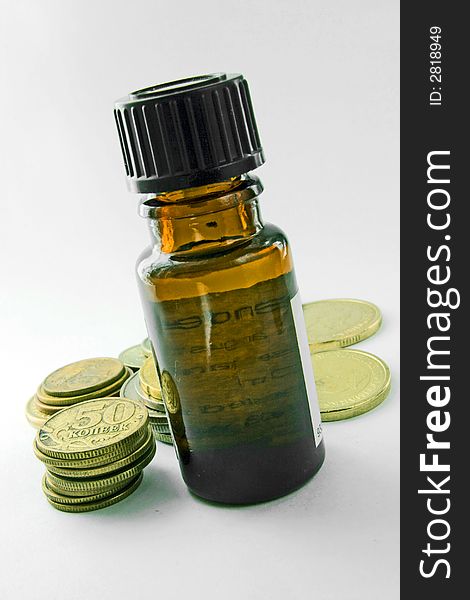 Inexpensive drugs in bottle golden coins white isolated background. Inexpensive drugs in bottle golden coins white isolated background