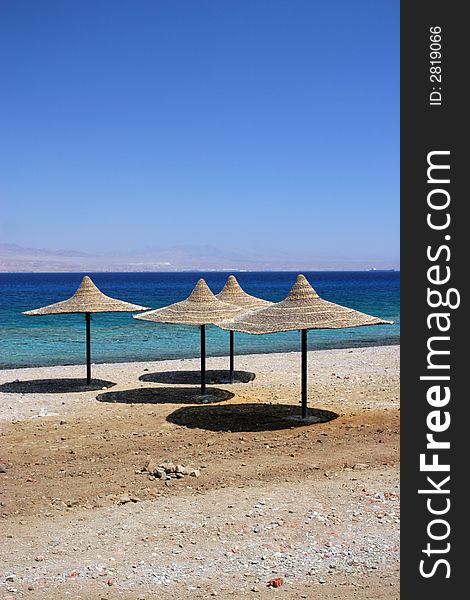 Umbrellas made of straw, on an empty beach. Umbrellas made of straw, on an empty beach.