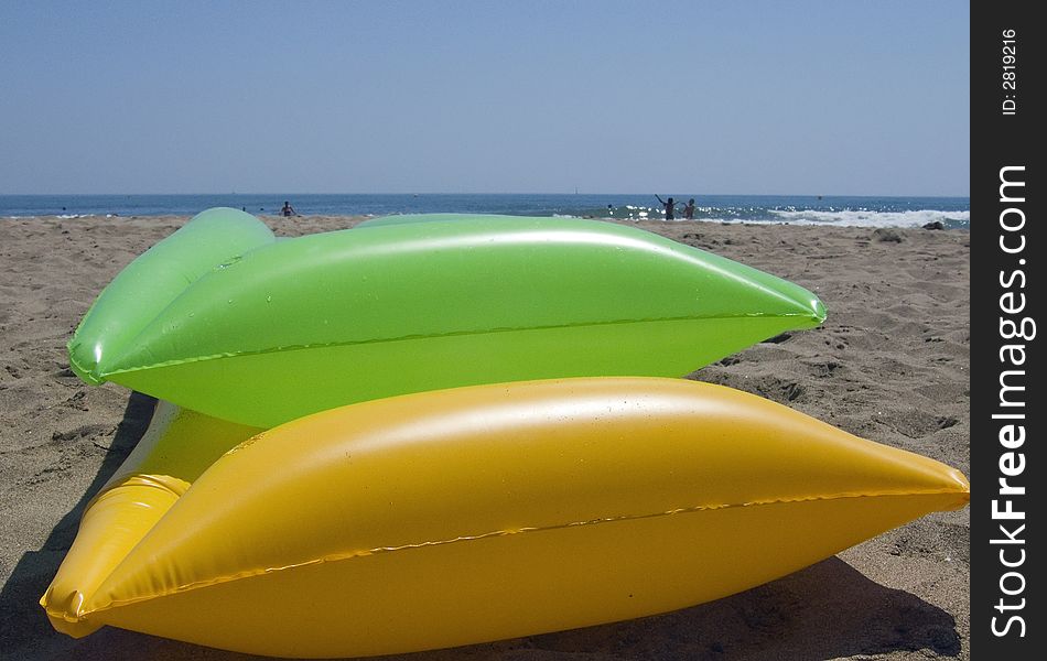 Yellow and green air mattrasses on the beach