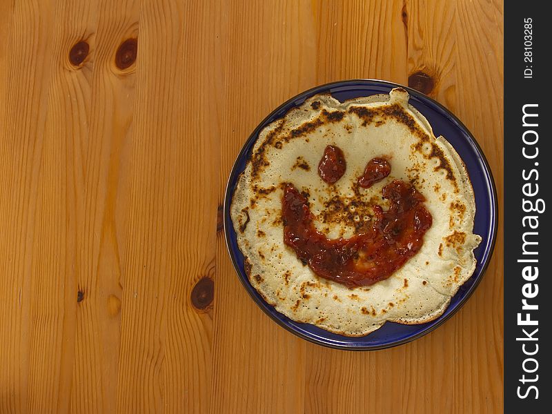 Top view on pancake with jam on blue plate