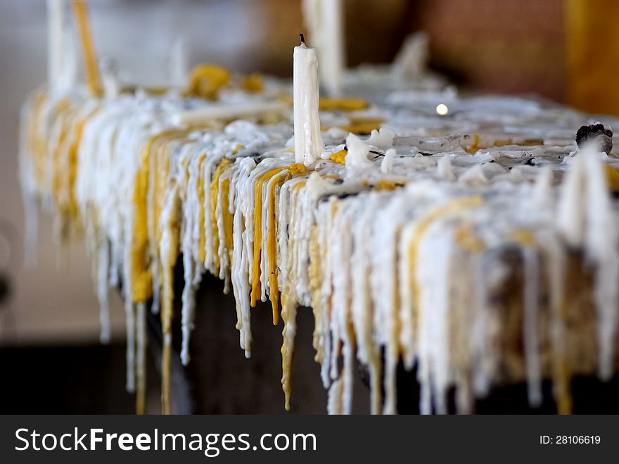 White and yellow dry candle tears hanging from the candle stand