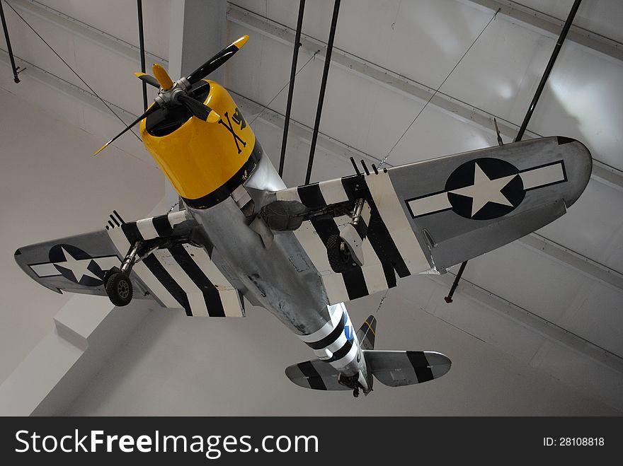 Vintage, historic, WW2 aircraft hanging from warehouse ceiling. Museum.