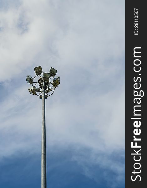 Spotlight pole with cloudy blue sky