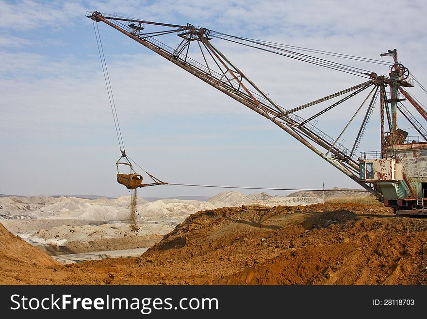 The powerful dredge digs a hole and transfers a ground to other place. The powerful dredge digs a hole and transfers a ground to other place