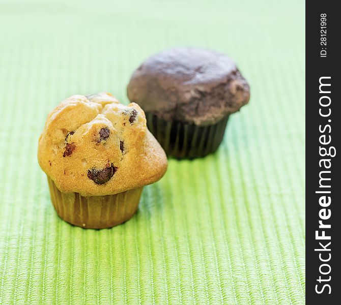 Chocolate chip muffins on green fabric