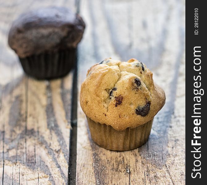 Chocolate chip muffins on old wooden table