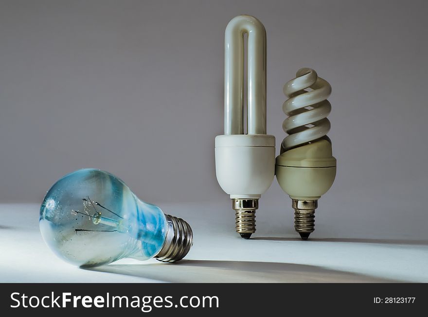 Three lamps: in the foreground - burned bulb with spiral torn and dirty with soot bulb, her two fluorescent without damage. Three lamps: in the foreground - burned bulb with spiral torn and dirty with soot bulb, her two fluorescent without damage