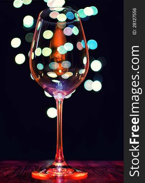 Empty wineglass on bokeh lights background