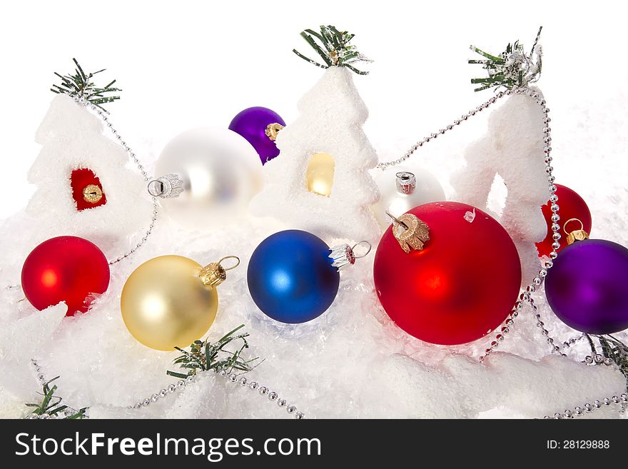 Christmas baubles and Christmas trees on snowy background.
