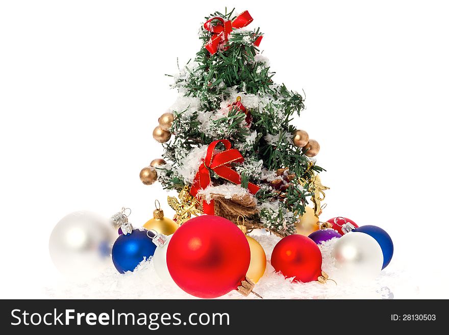 Christmas tree with baubles and snow isolated on white.