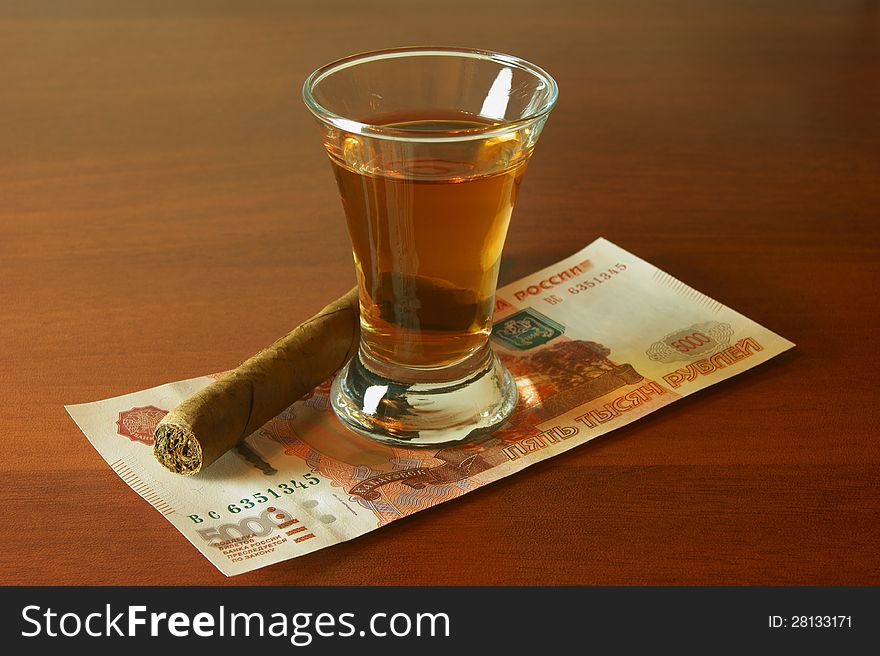 Alcohol, wallet, money and a cigar on the table. Alcohol, wallet, money and a cigar on the table