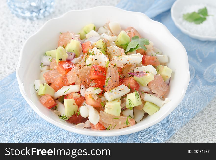 Bowl of salad with squid, avocado and grapefruit, top view