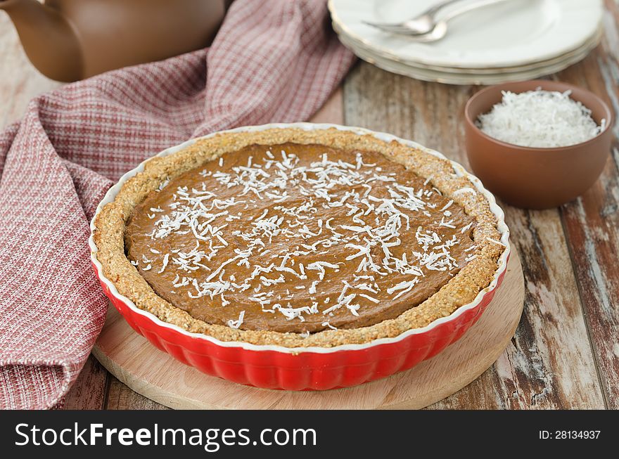 Pie with pumpkin and chocolate in ceramic form on a wooden table. Pie with pumpkin and chocolate in ceramic form on a wooden table