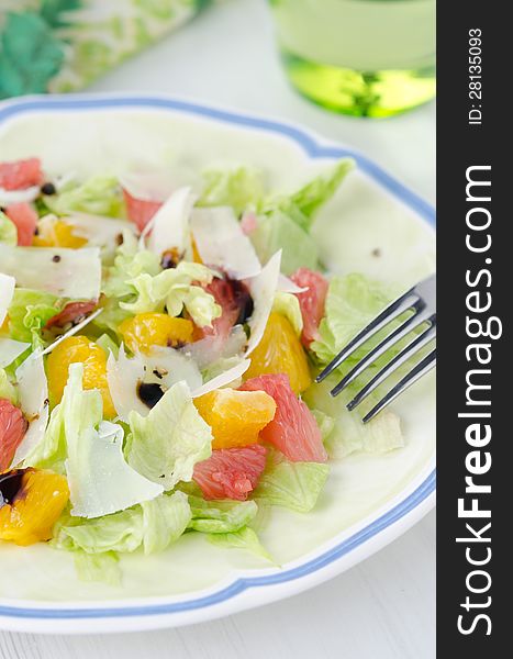 Salad with grapefruit, oranges, lettuce and cheese on a plate closeup. Salad with grapefruit, oranges, lettuce and cheese on a plate closeup