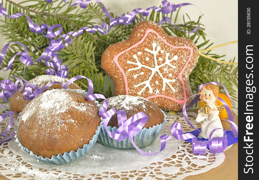 Three Christmas muffins with angel, purple ribbon and the conifer branch