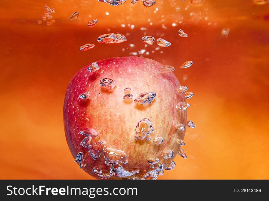 Red apple in water with some bubble