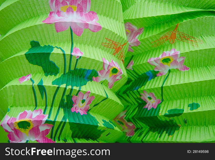 Closeup of two green Chinese paper lanterns with a floral design for a New Year's celebration