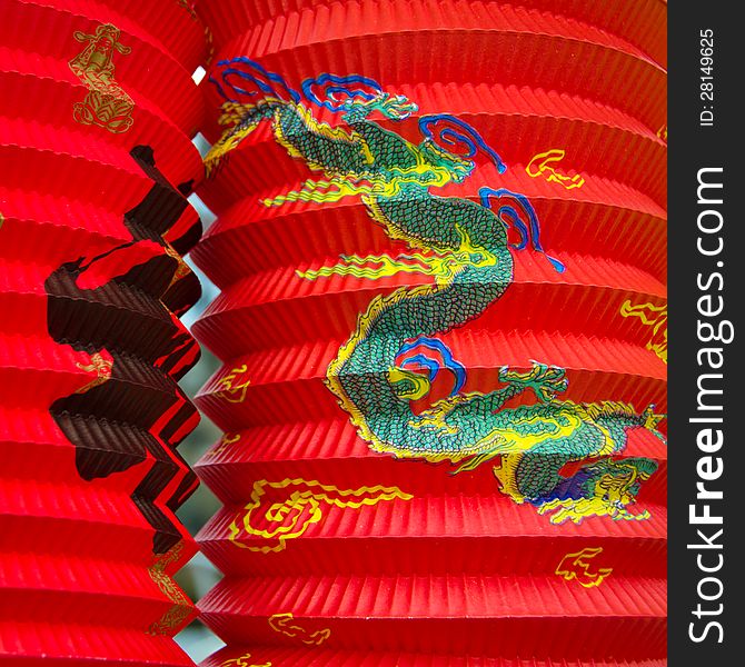 Closeup of two red Chinese paper lanterns illustrated with a dragon and calligraphy