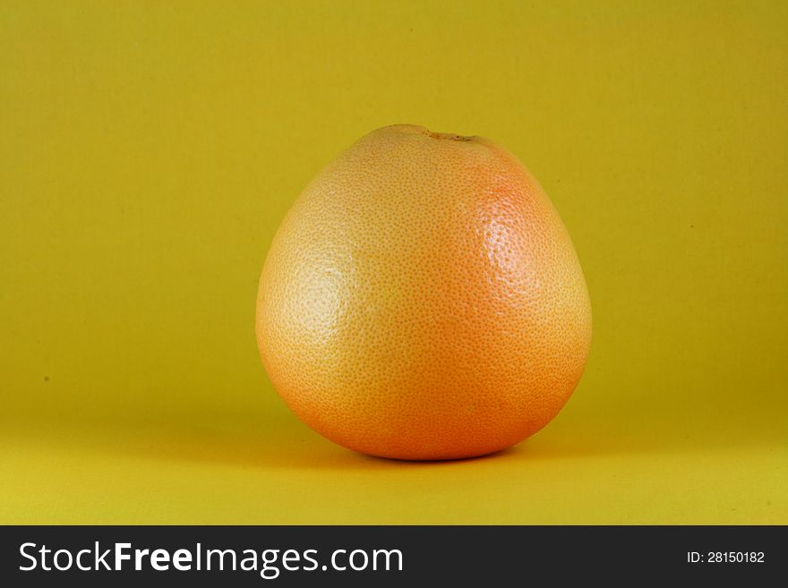 A fresh orange on yellow background