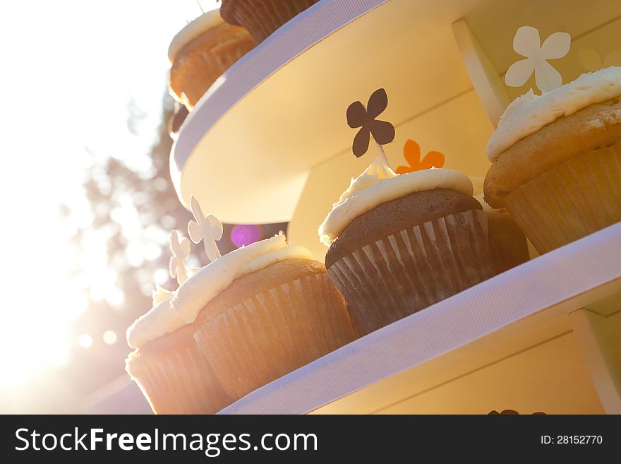 Three types of wedding cupcakes at a dessert recepition outdoors.