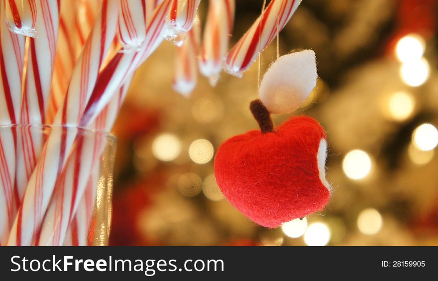 Handmade red apple with bite on a bunch of christmas candy cane. Handmade red apple with bite on a bunch of christmas candy cane