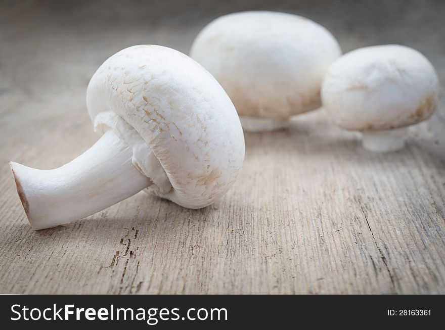 Mushroom champignon group on wood texture