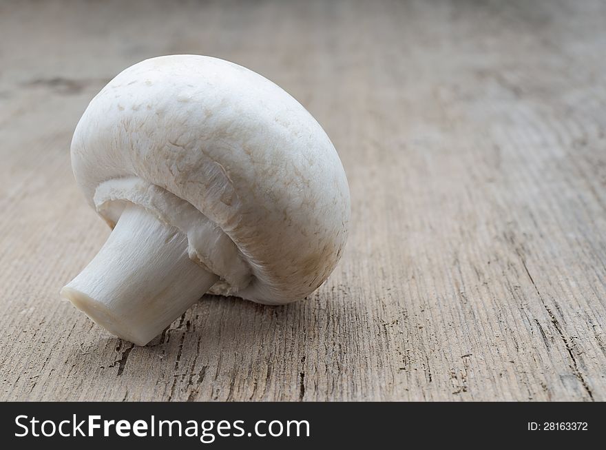 Mushroom champignon on wood texture