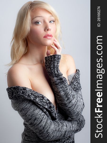 An image of a pretty young woman in a sweater pulled down low on her shoulders. An image of a pretty young woman in a sweater pulled down low on her shoulders