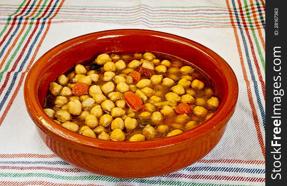 Chickpeas in old ceramic plate with wooden spoon