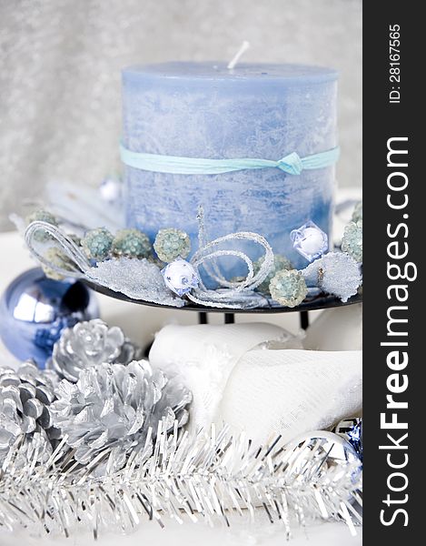 Close up blue candle decorated with christmas ornaments