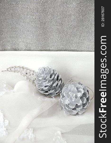 Silver pine cones on white and silver background. Silver pine cones on white and silver background