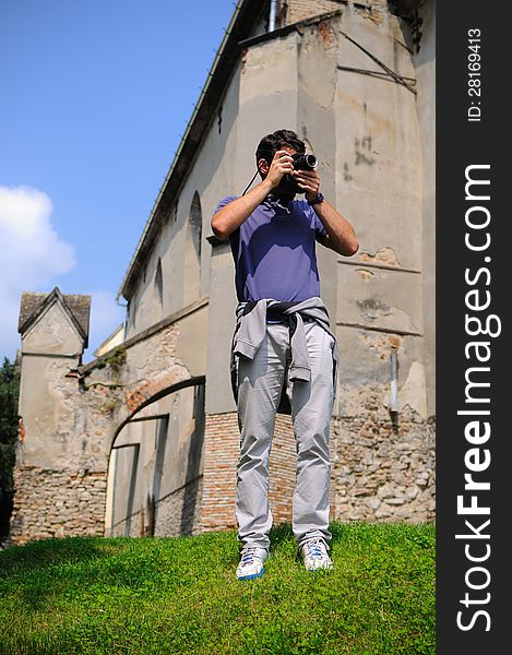 Casual tourist taking photos of medieval castle ruins. Casual tourist taking photos of medieval castle ruins.