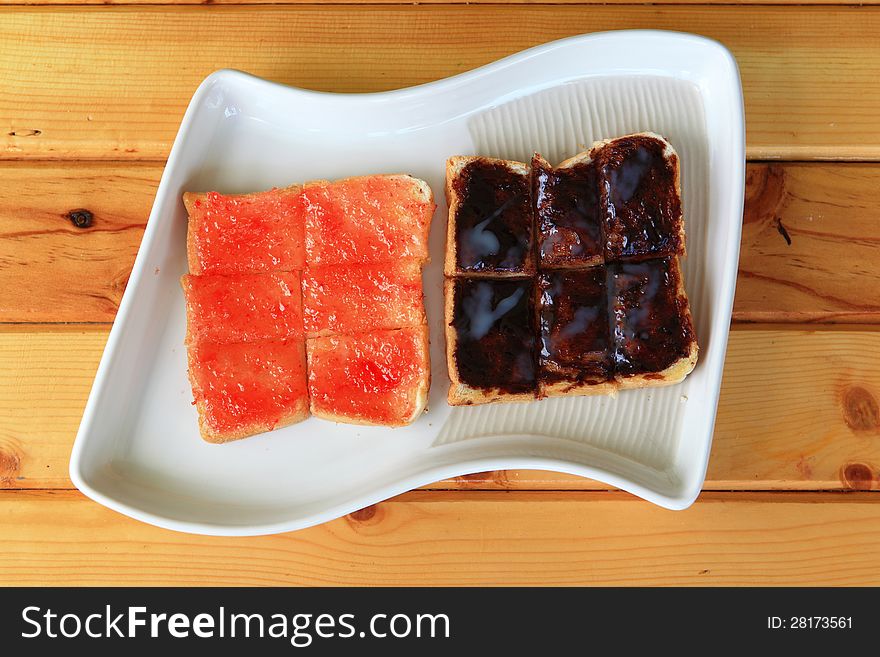 Slice of bread with jam on white dish. Slice of bread with jam on white dish