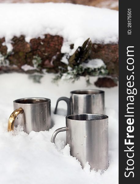 Thermos cups stand in the snow outdoors. Thermos cups stand in the snow outdoors