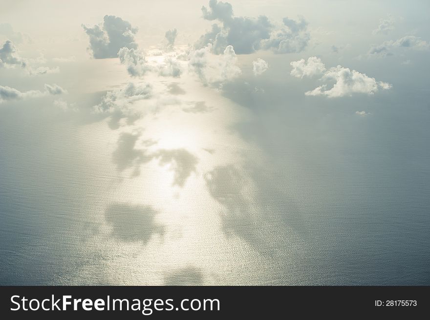 View from above on ocean, clouds, sky and sun