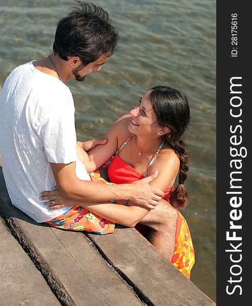 Loving couple looking at each other on the pier. Loving couple looking at each other on the pier