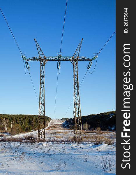 Tower of a high-voltage electric line, in a sunny day against the blue sky. Tower of a high-voltage electric line, in a sunny day against the blue sky