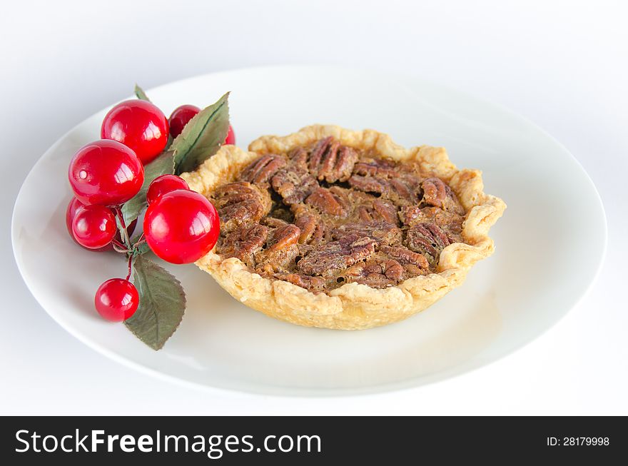 Christmas tart decorated with artificial cherries on a white plate. Christmas tart decorated with artificial cherries on a white plate.