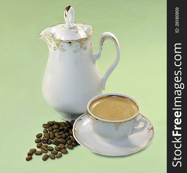 On the photograph shown coffee in a white cup. Nearby is a coffee pot and coffee beans scattered. Objects are on a green background.