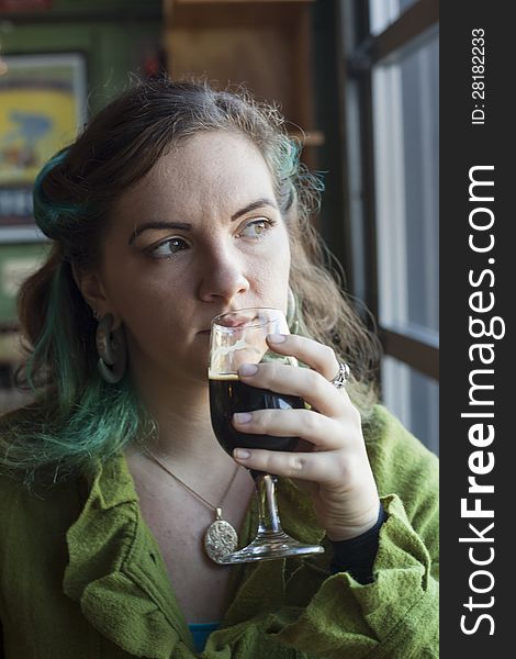 Young woman drinking a pint of beer at a pub. Young woman drinking a pint of beer at a pub