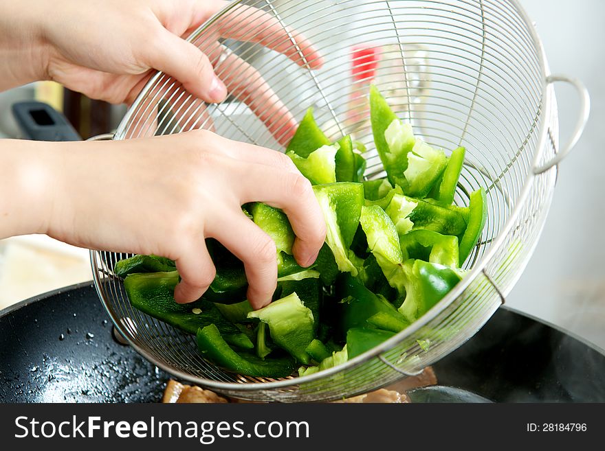 Hand with Chopped Green Bell Pepper in a silver screen. Hand with Chopped Green Bell Pepper in a silver screen