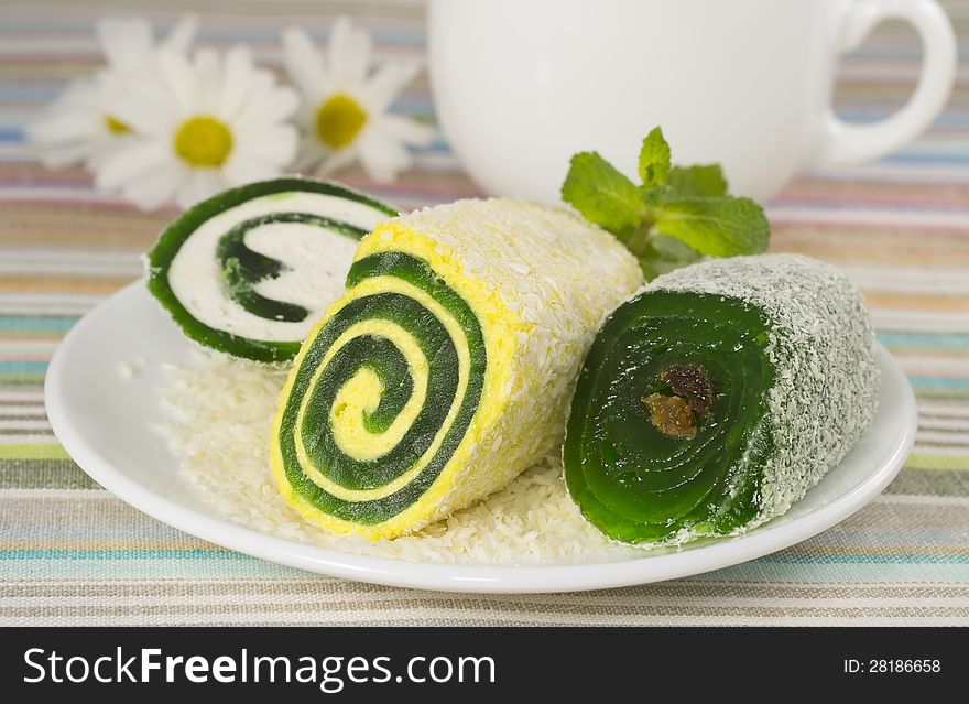 Roll dessert in a plate with flower, closeup