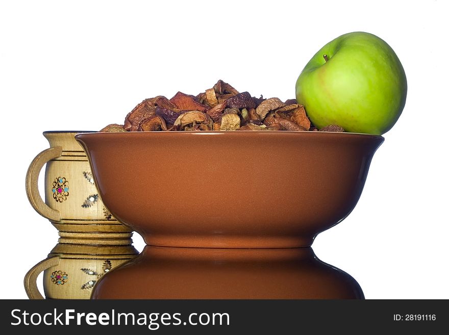 Ceramic bowl with dried apples and green apple