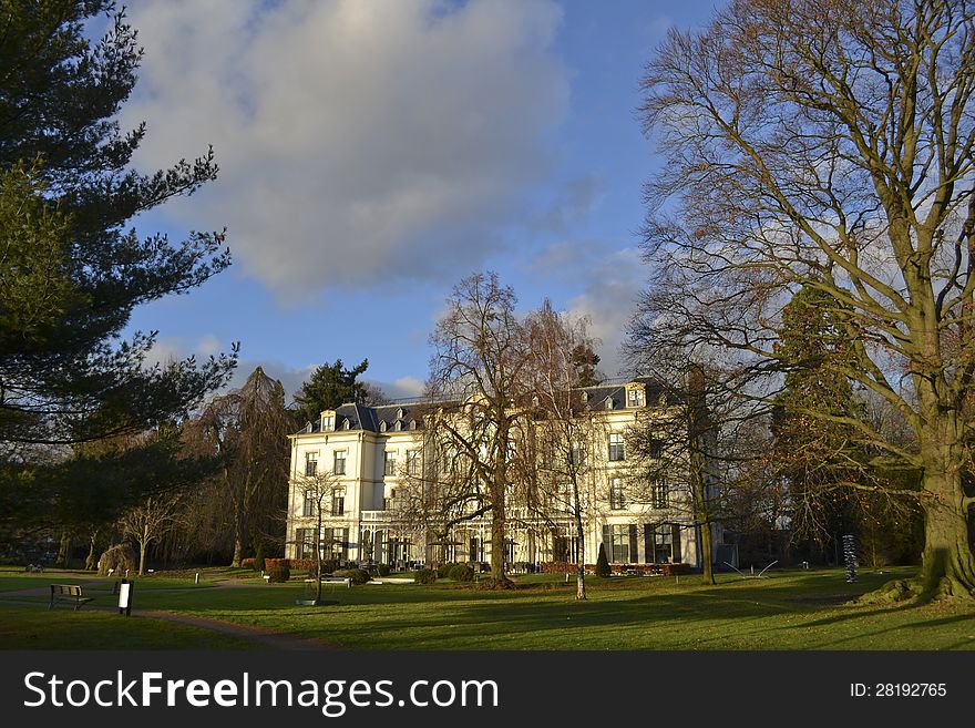 In a park in Holland you see a white villa. In a park in Holland you see a white villa